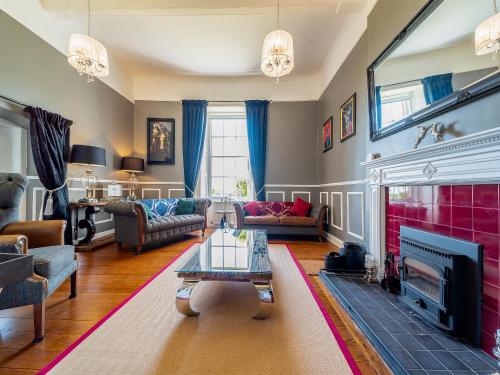 a living room with a fireplace and a tv at Mossknowe Escape in Annan
