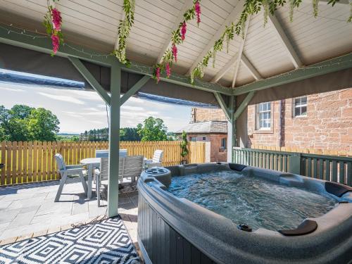 a hot tub on the patio of a house at Mossknowe Escape in Annan