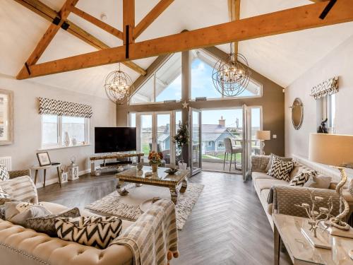 a living room with couches and a tv at Stargazer in Beadnell