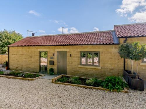 a brick house with a garden in front of it at Rinstone Lodge in Thornton Dale