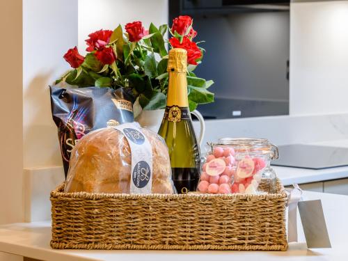 a basket with a bottle of champagne and bread and flowers at Rinstone Lodge in Thornton Dale