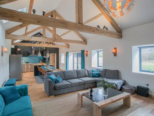 a living room with a couch and a table at The Pendre Longbarn in Pentre-briwnant