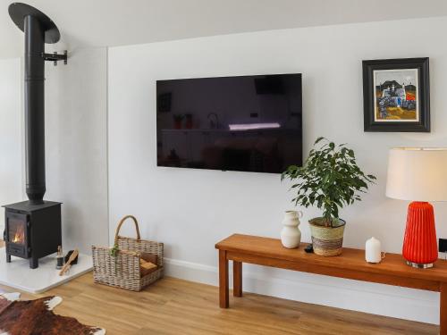 a living room with a fireplace and a table with a plant at Ty Twm in Criccieth