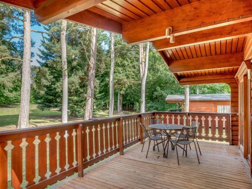 a wooden deck with a table and chairs on it at Cherry Lodge- Uk37608 in Legbourne
