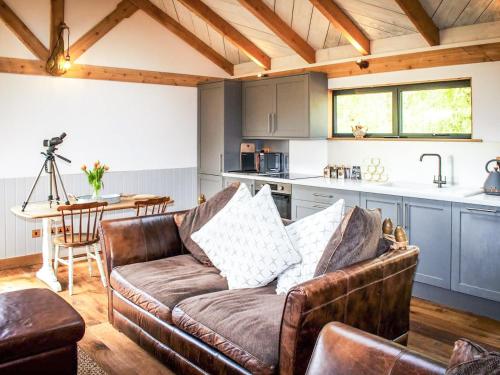 a living room with a couch and a kitchen at Meadow Hide - Uk36773 in Chichester