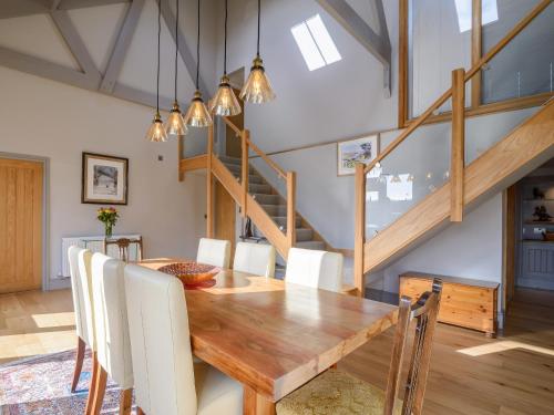 a dining room with a wooden table and white chairs at Penthwaite in Leyburn
