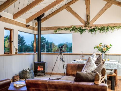a living room with a fireplace and a couch at Meadow Hide - Uk36773 in Chichester