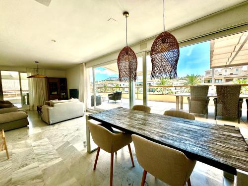 a dining room with a wooden table and chairs at Penthouse Seven Oceans Moraira in Moraira
