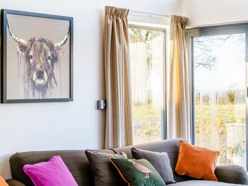 a living room with a couch and a picture of a bull at Y Glowty Newydd - Uk31701 in Llandissilio
