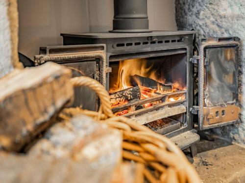 a brick oven with a fire in it at Hob Cote - Cottage in Heptonstall