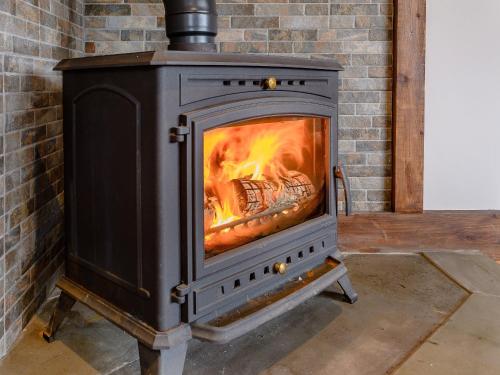 a stove with a fire in a brick fireplace at Olive Lodge in Melbourne