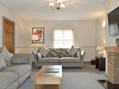 a living room with two couches and a tv at Ty Fynnon Cottage-Uk2786 in Penmaen-mawr