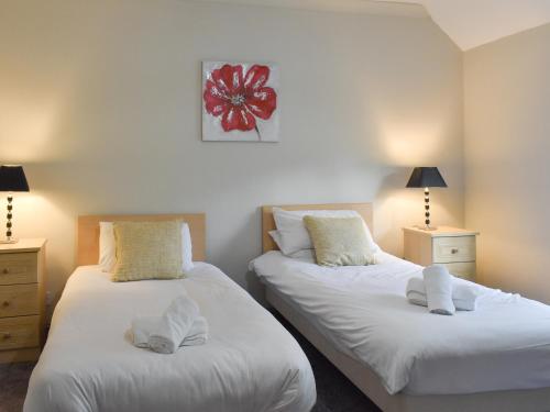 two beds sitting next to each other in a bedroom at Ty Fynnon Cottage-Uk2786 in Penmaen-mawr
