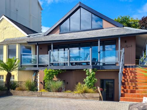 a house with large glass doors and windows at Beachfront Apartment in Rhos-on-Sea