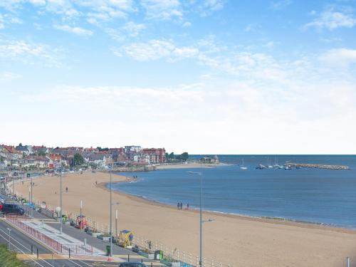 a view of a beach with buildings and the ocean at Beachfront Apartment in Rhos-on-Sea