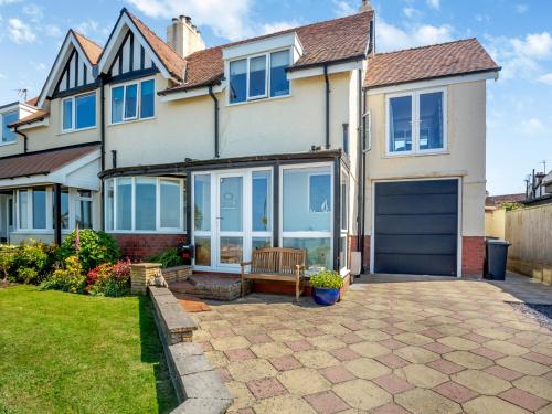a large house with a garage and a driveway at Waterside in Llandrillo-yn-Rhôs