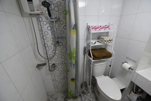 a bathroom with a shower curtain and a toilet at Rayong Condochain 325 in Ban Pak Khlong Phe