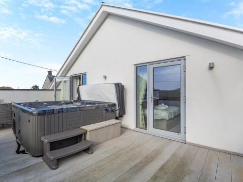 a bathroom with a hot tub on a patio at Hafod Y Morfa - Uk48829 in Harlech