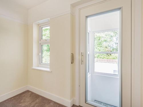 an empty room with a door and two windows at Seacroft Lodge in Skegness