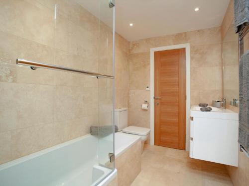 a bathroom with a tub and a toilet and a sink at Soft Sands - Cottage in Woolacombe