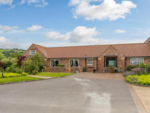 a brick house with a driveway in front of it at The Stables in Cheddar