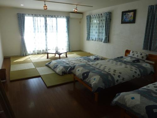 ein Schlafzimmer mit zwei Einzelbetten und einem Fenster in der Unterkunft Sora-mame in Yakushima