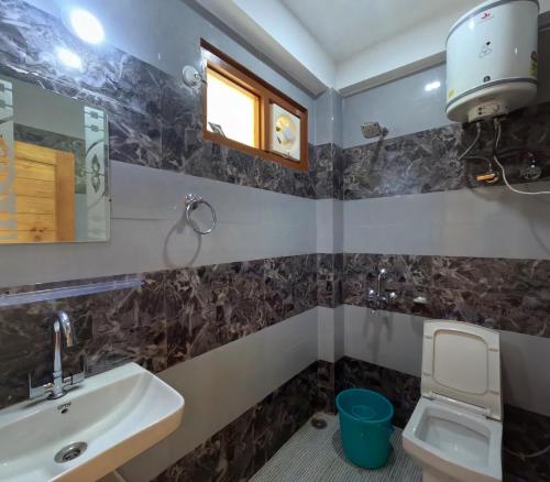 a bathroom with a sink and a toilet at Jumanji homestay in Nagar