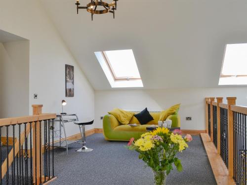 a living room with a green couch and a table at Holmegarth in Plumbland