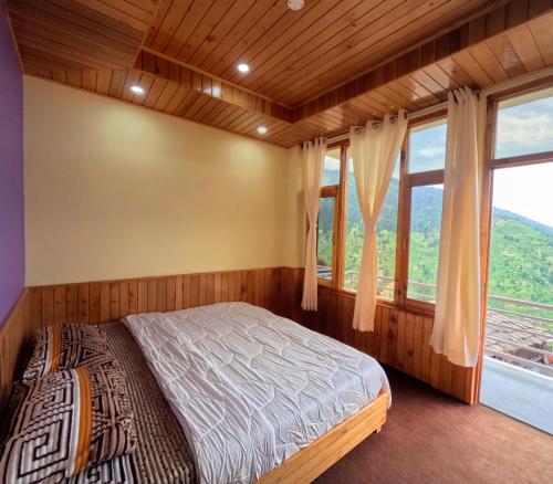a bedroom with a bed and a large window at Jumanji homestay in Nagar