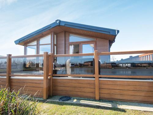 a small wooden house with a wooden fence at Buff Lake - Uk37725 in Ingoldmells