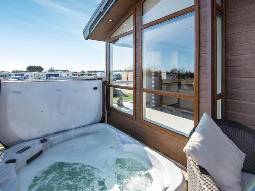 a hot tub on a balcony with a window at Buff Lake - Uk37725 in Ingoldmells