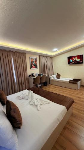 ein Hotelzimmer mit einem großen Bett und einem Tisch in der Unterkunft AKS Hotel in Taschkent