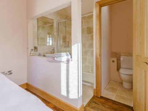 a bathroom with a shower and a toilet and a sink at The Cornstore - Uk32513 in Marloes