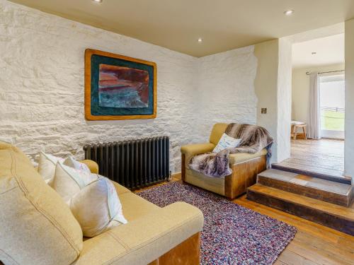 a living room with a couch and a chair at The Cornstore - Uk32513 in Marloes