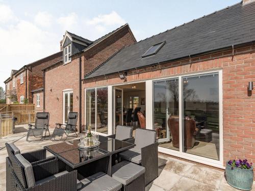 an extension of a house with a patio with a table and chairs at Lizzie's Cottage in Skendleby