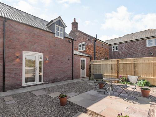 a courtyard of a brick house with a table and chairs at Lizzie's Cottage in Skendleby