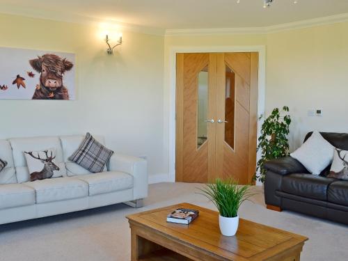 a living room with a white couch and a coffee table at Wheatfield House in Kilmaurs