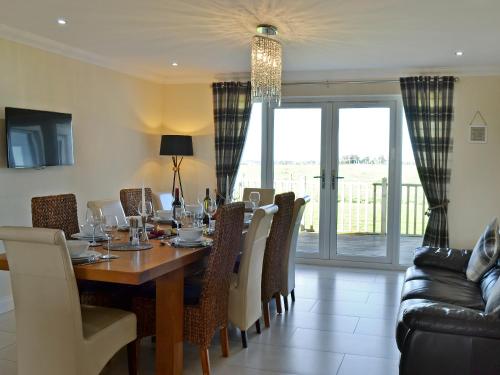 a dining room with a wooden table and chairs at Wheatfield House in Kilmaurs