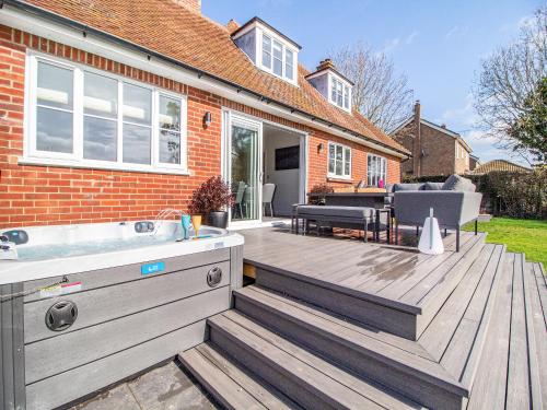 a wooden deck with a bath tub on a house at Longridge in Peldon