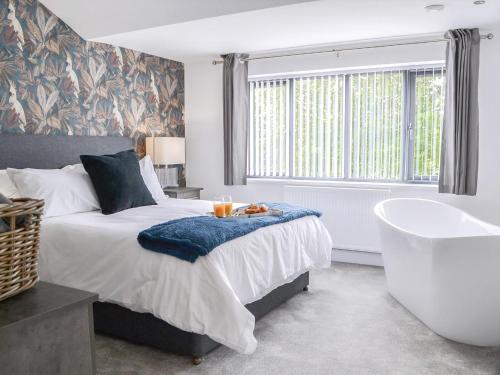 a bedroom with a large bed and a bath tub at Linden Manor in Bridlington