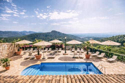 a swimming pool with chairs and umbrellas at Posada del Marqués I A Slow Design Hotel in Esporles