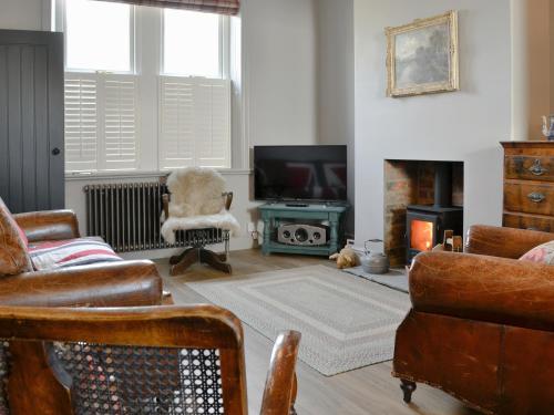 a living room with a couch and a television at Dick 'N' Liddy's in Gargrave