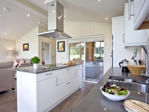 a kitchen with white cabinets and a bowl of food on a counter at Willow Lodge in Hassocks
