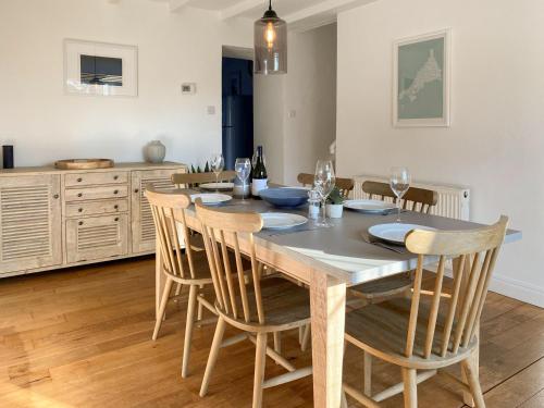 a dining room with a wooden table and chairs at Barn Cottage in Saint Mawgan