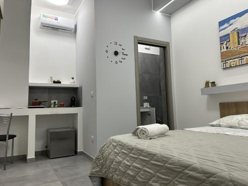 a bedroom with a bed and a clock on the wall at La Pescheria - Mini Apartments in Catania