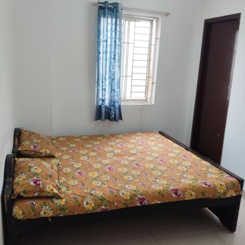 a bed in a room with a window at Sifa Guest House in Chennai