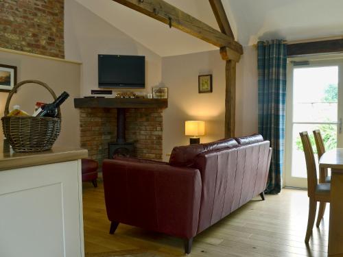 a living room with a couch and a fireplace at Rose Cottage in Rillington