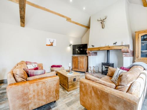 a living room with two couches and a fireplace at The Old Stables in Cumberworth