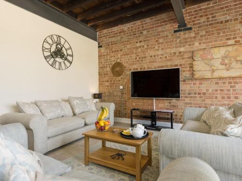 a living room with couches and a brick wall at Church View - Ukc2302 in Wainfleet All Saints