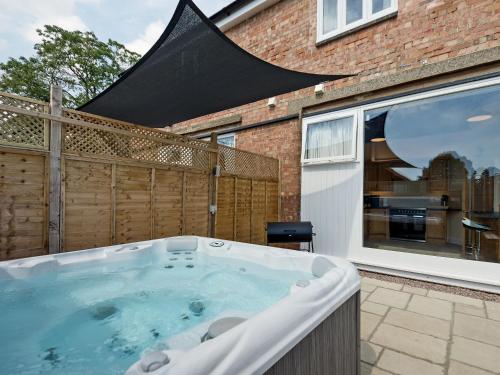 a hot tub in the backyard of a house at Church View - Ukc2302 in Wainfleet All Saints